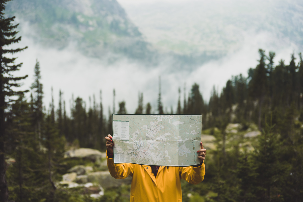 Camper Holding a Map Outdoors